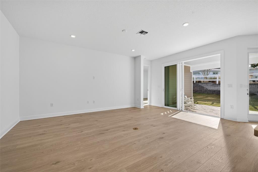 983 Fiesta Key Circle Lady Lake, FL 32159 - Photo 13 of 39 a view of an empty room with wooden floor and a window