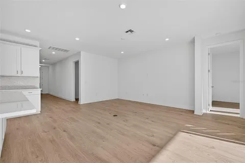 wooden floor in an empty room with a kitchen