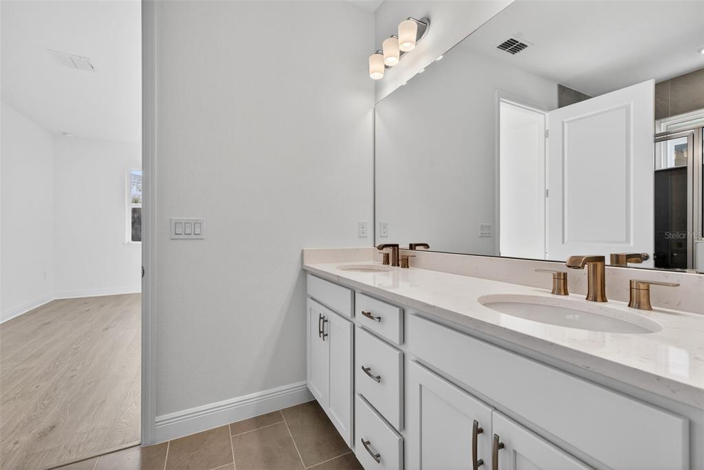 983 Fiesta Key Circle Lady Lake, FL 32159 - Photo 19 of 39 a bathroom with a double vanity sink and mirror