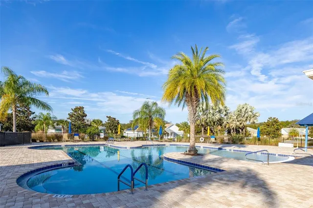 a swimming pool view with a seating space and a garden