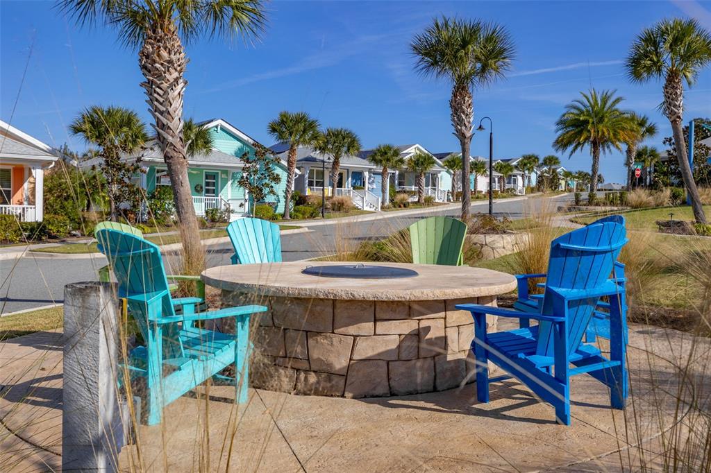 983 Fiesta Key Circle Lady Lake, FL 32159 - Photo 39 of 39 a view of a patio with table and chairs potted plants and palm tree