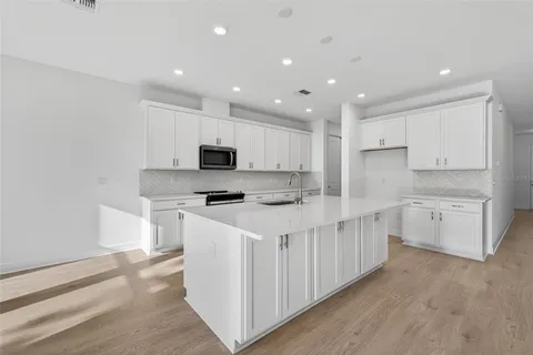 a kitchen with appliances a sink and cabinets