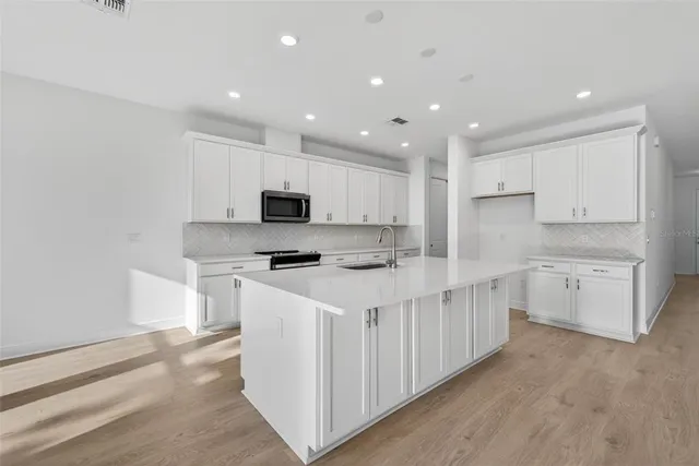 a kitchen with appliances a sink and cabinets