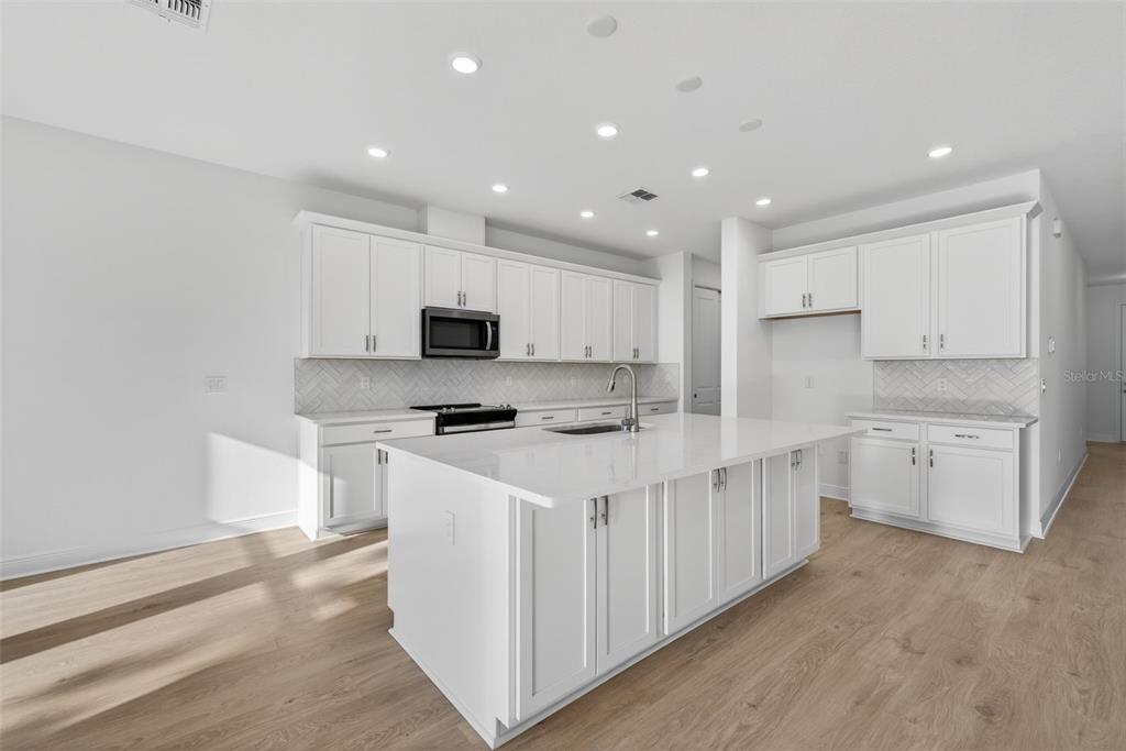 983 Fiesta Key Circle Lady Lake, FL 32159 - Photo 7 of 39 a kitchen with appliances a sink and cabinets