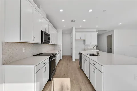 a kitchen with stainless steel appliances granite countertop a sink stove and microwave