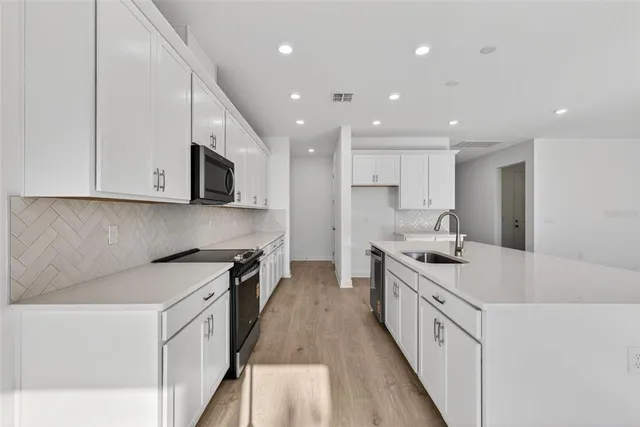 a kitchen with stainless steel appliances granite countertop a sink stove and microwave