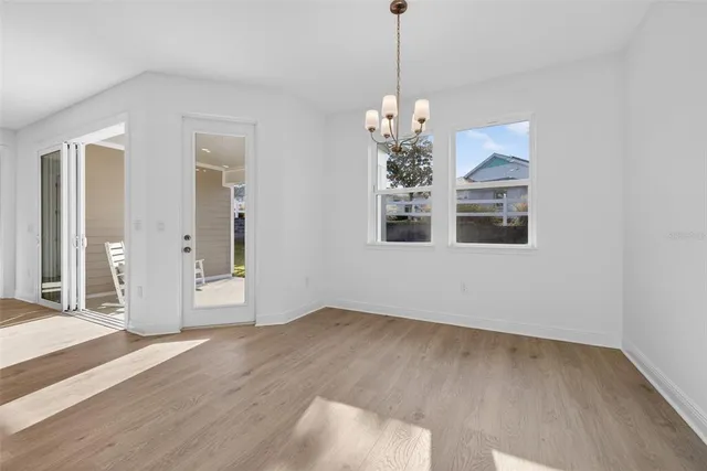 a view of an empty room with window and wooden floor