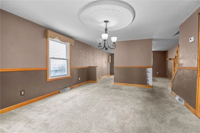 an empty room with windows and chandelier