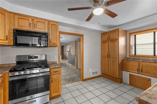 a kitchen with granite countertop a stove cabinets and stainless steel appliances