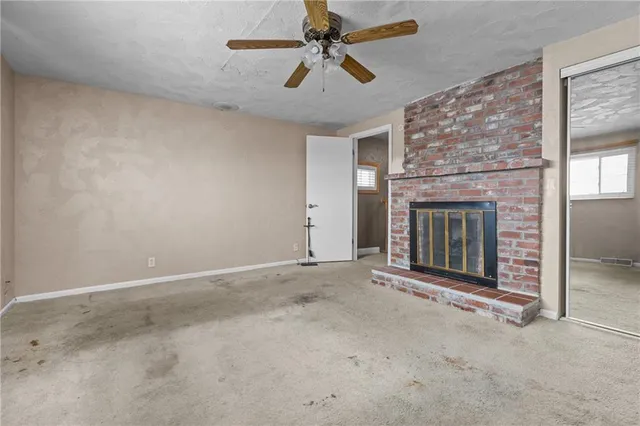 an empty room with fireplace and fan