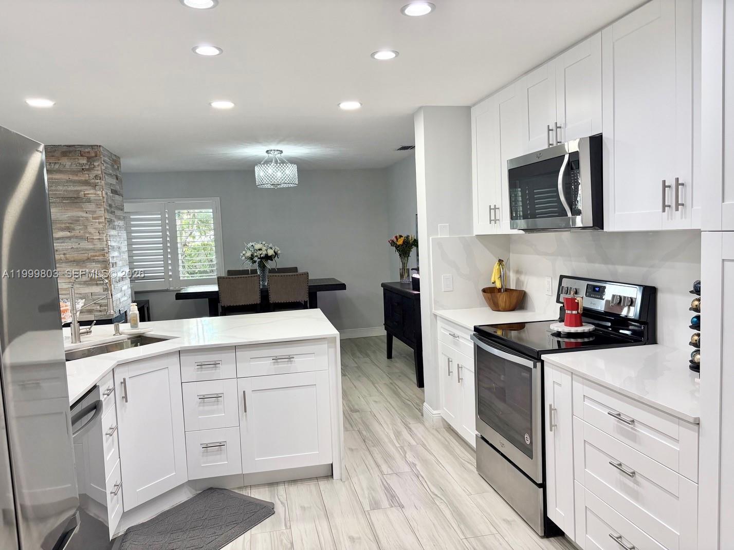 6728 Boca Pines Trail, Unit B Boca Raton, FL 33433 - Photo 3 of 30 a kitchen with a stove a sink and a microwave