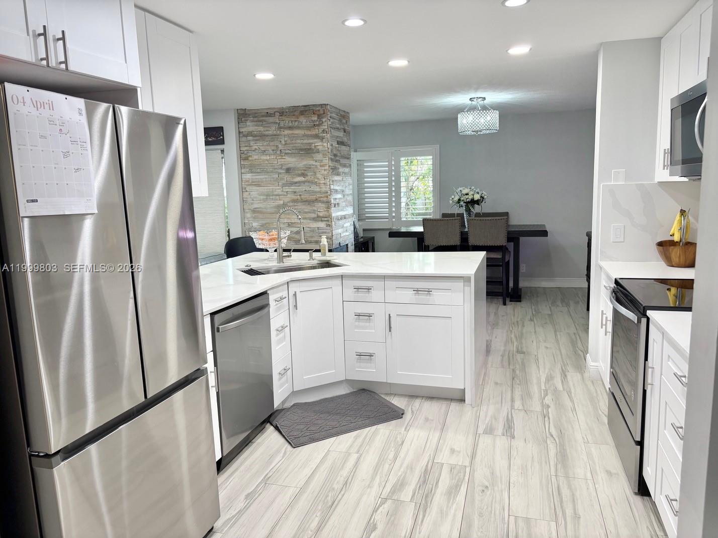 6728 Boca Pines Trail, Unit B Boca Raton, FL 33433 - Photo 6 of 30 a kitchen with a sink a refrigerator a washer and dryer