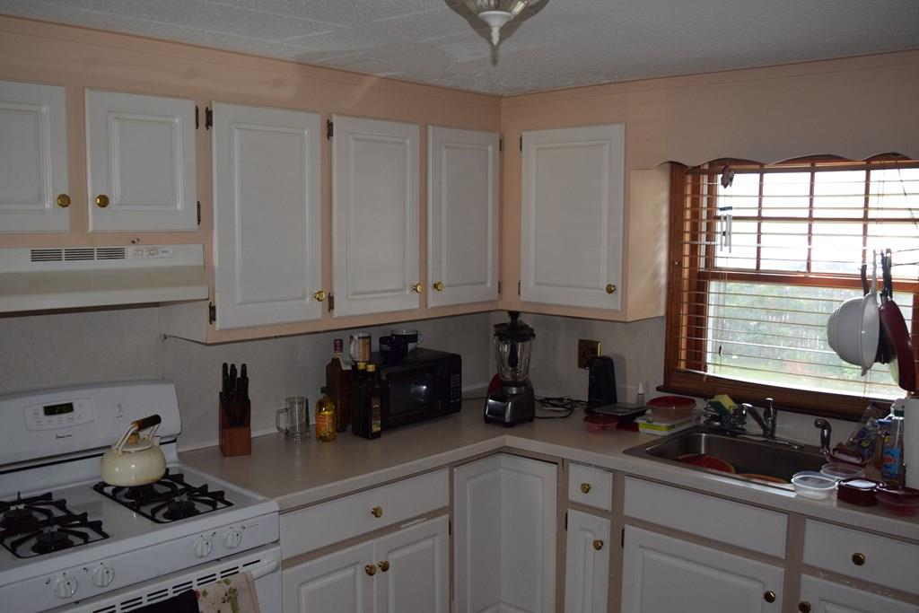 182 Merrimac Avenue Springfield, MA 01104 - Photo 8 of 18 a kitchen with white cabinets and a stove top oven