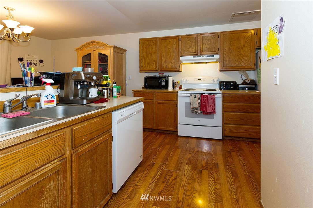 531 Duchess Road Bothell, WA 98012 - Photo 5 of 25 a kitchen with a sink wooden floor and black appliances