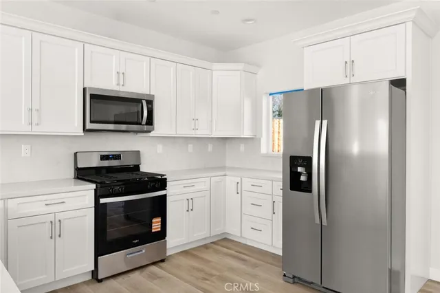 a kitchen with white cabinets and stainless steel appliances