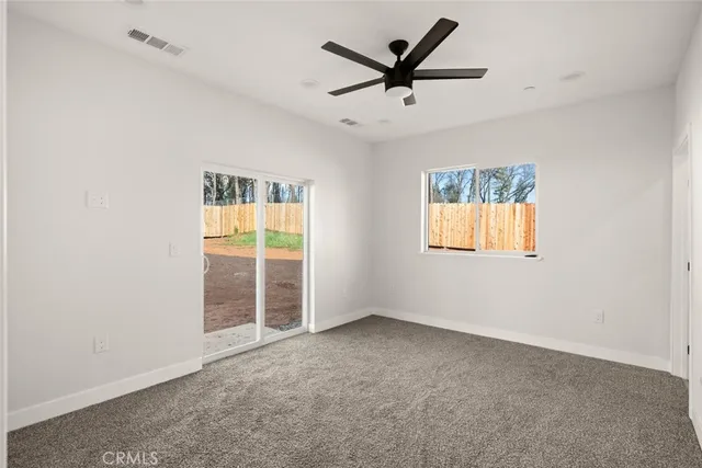 an empty room with a ceiling fan and window