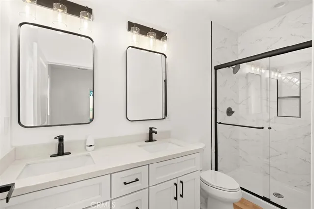 a bathroom with a double vanity sink mirror and toilet