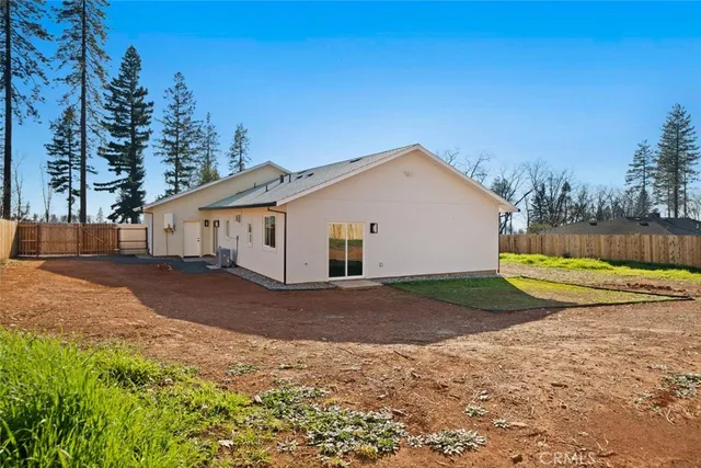 a view of a house with backyard and trees