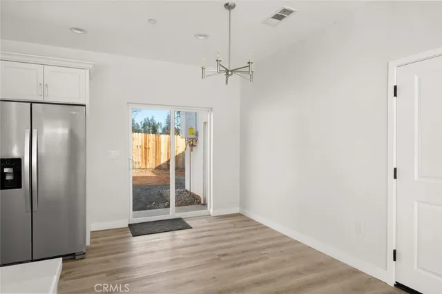 a view of a refrigerator in kitchen and wooden floor