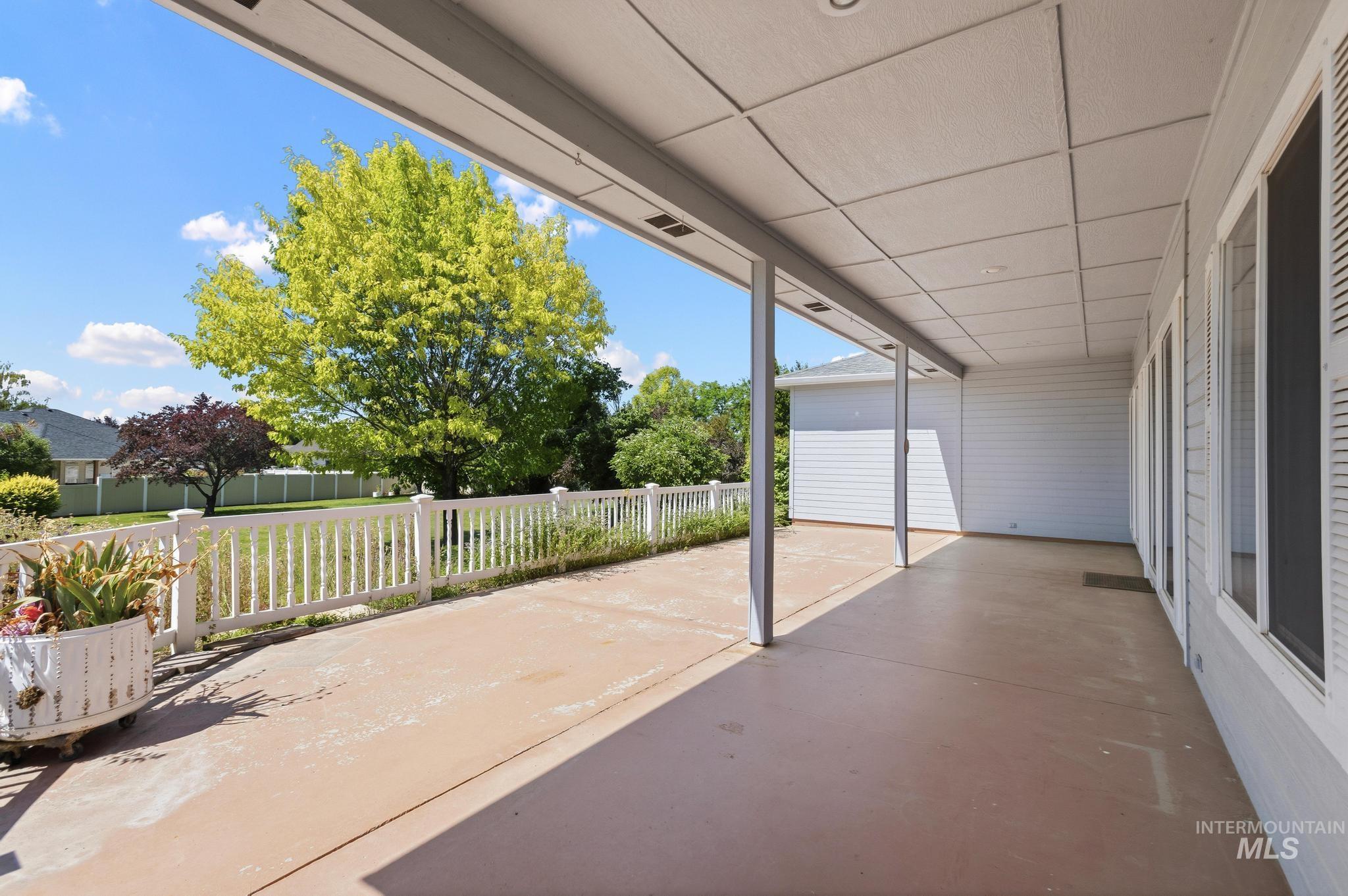 15181 Drury Way Caldwell, ID 83607 - Photo 32 of 49 Expansive covered patio featuring a concrete surface, white vinyl siding, multiple exterior windows with white shutters, and recessed lighting