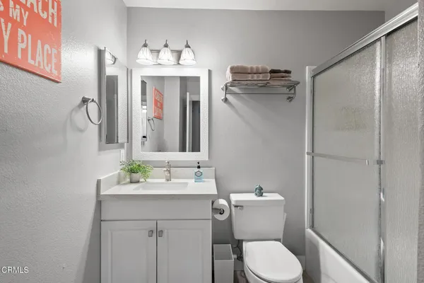 a bathroom with a sink vanity mirror and toilet