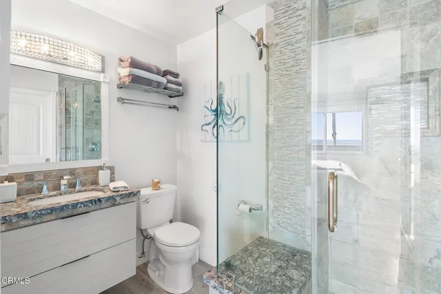 a bathroom with a granite countertop sink toilet and shower
