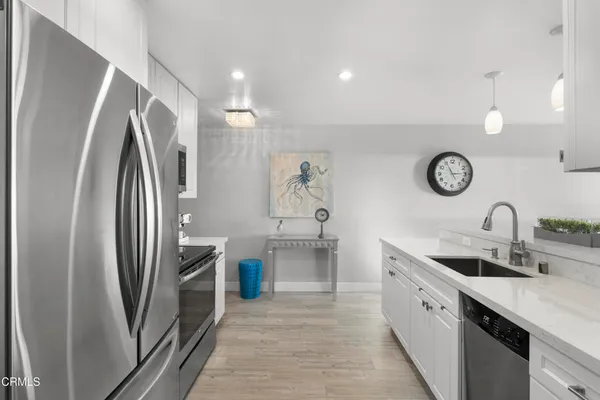 a kitchen with stainless steel appliances granite countertop a refrigerator and a sink