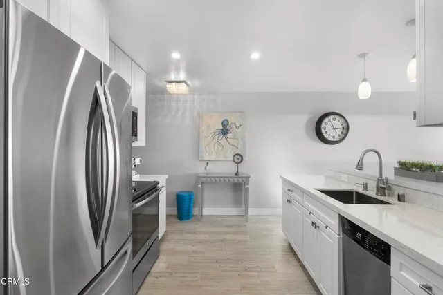 a kitchen with stainless steel appliances granite countertop a refrigerator and a sink