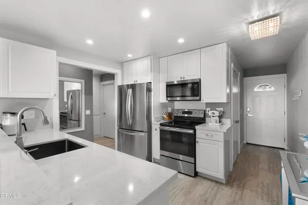 a kitchen with granite countertop a refrigerator stove and sink