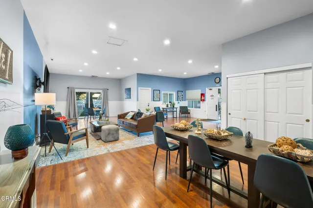 a living room with furniture a chandelier and a dining table