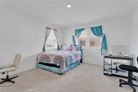 a bedroom with a bed chair and a window