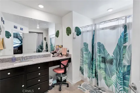 a spacious bathroom with a granite countertop sink a mirror and shower