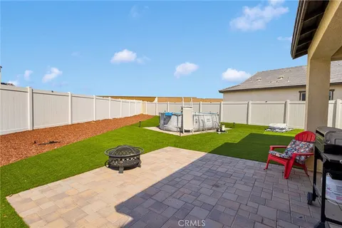 a view of a patio with table and chairs with wooden fence
