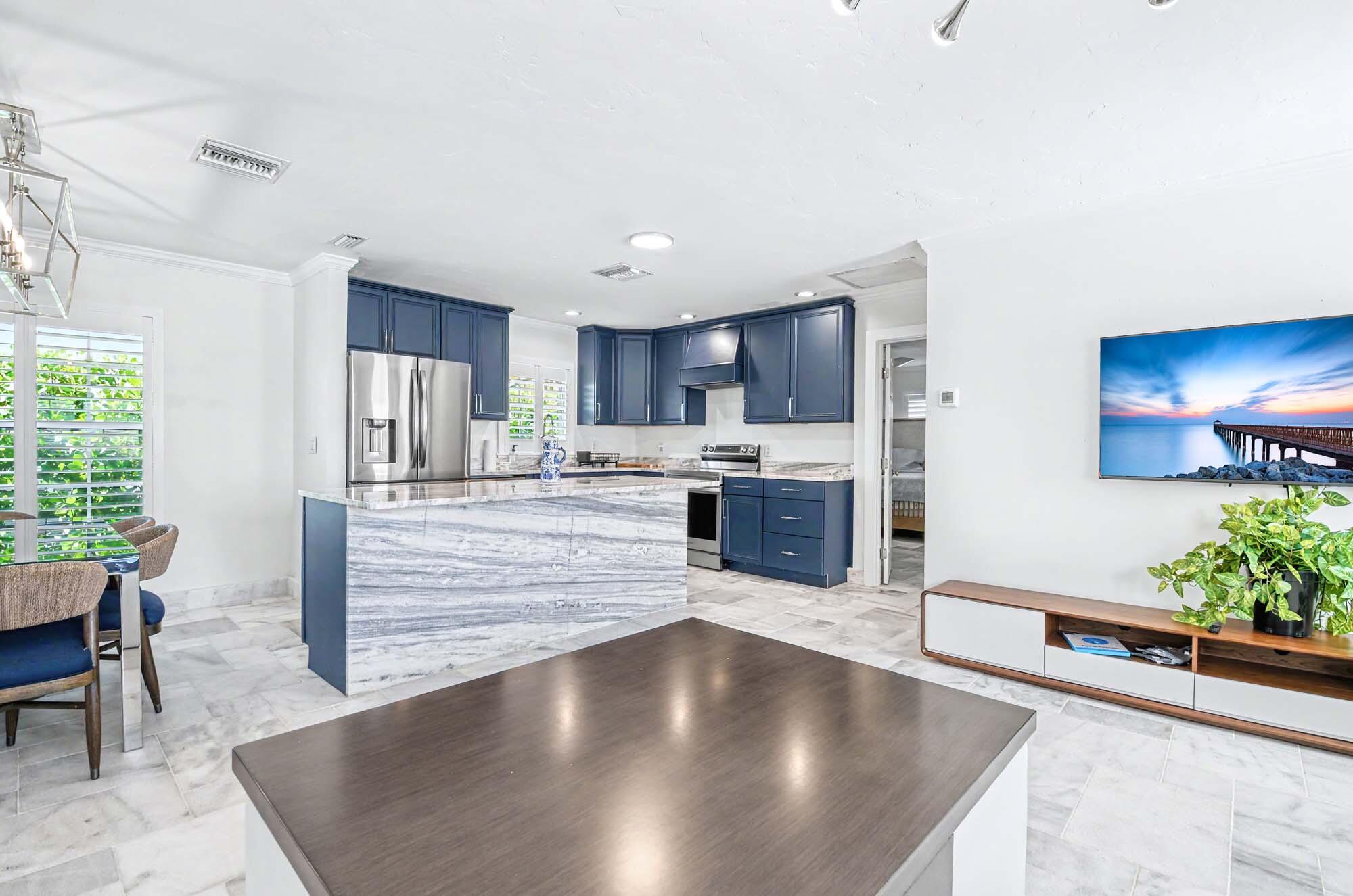 112 Capri Boulevard Naples, FL 34113 - Photo 7 of 29 a large kitchen with kitchen island a counter top space a sink stainless steel appliances and cabinets