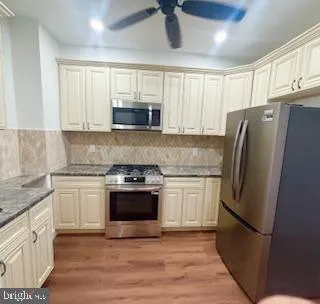 a kitchen with stainless steel appliances a refrigerator sink and microwave