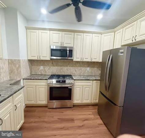 a kitchen with stainless steel appliances granite countertop a refrigerator stove a sink and microwave