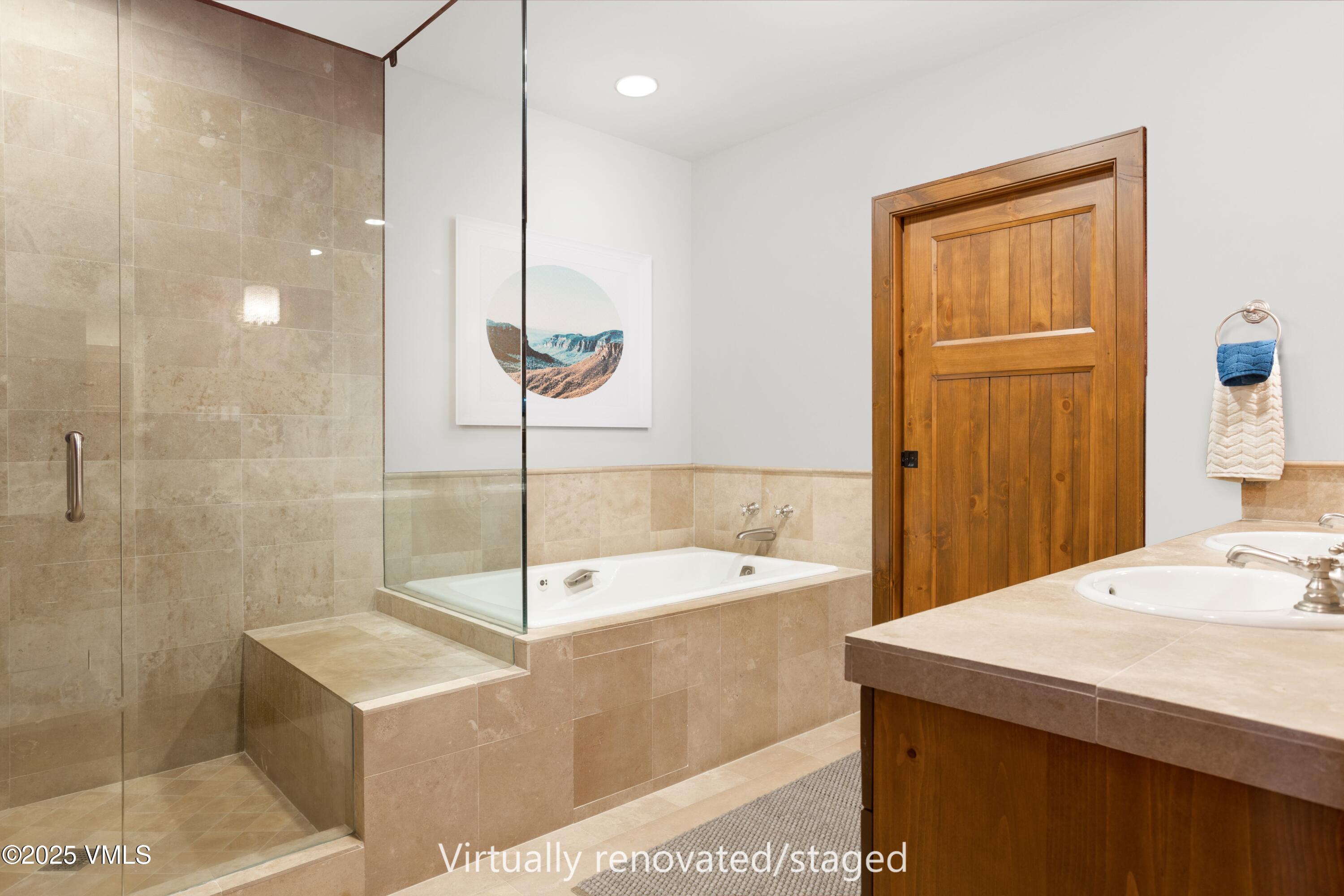 180 Daybreak Ridge Road, Unit 410 Avon, CO 81620 - Photo 17 of 30 a bathroom with a sink a bathtub and a shower