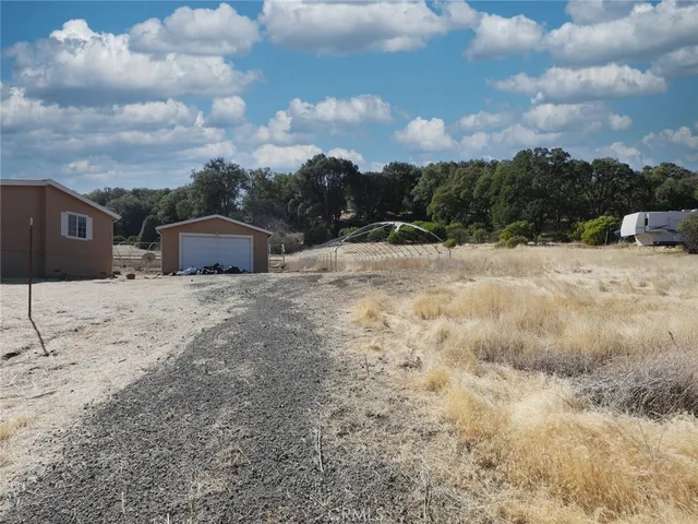 a view of a dry yard with wooden fence