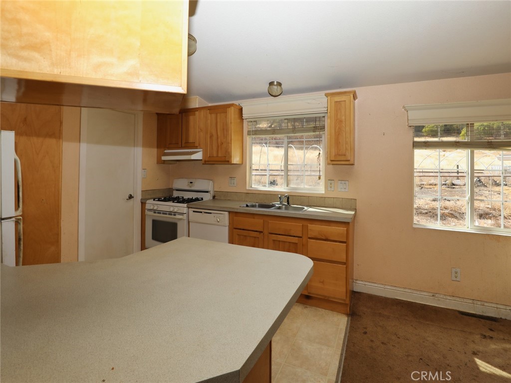 9520 Rocky Creek Road Lower Lake, CA 95457 - Photo 26 of 40 a kitchen with stainless steel appliances granite countertop a sink a stove and a refrigerator