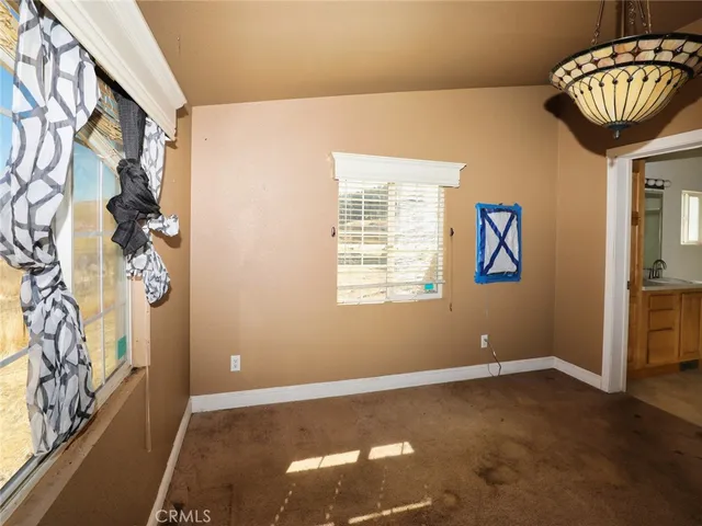 an empty room with fan and windows