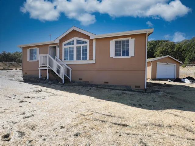 a front view of a house with a yard covered with snow