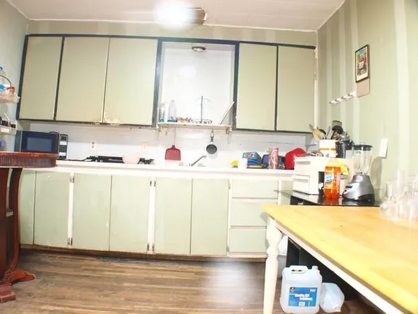 a kitchen with a sink cabinets and wooden floor