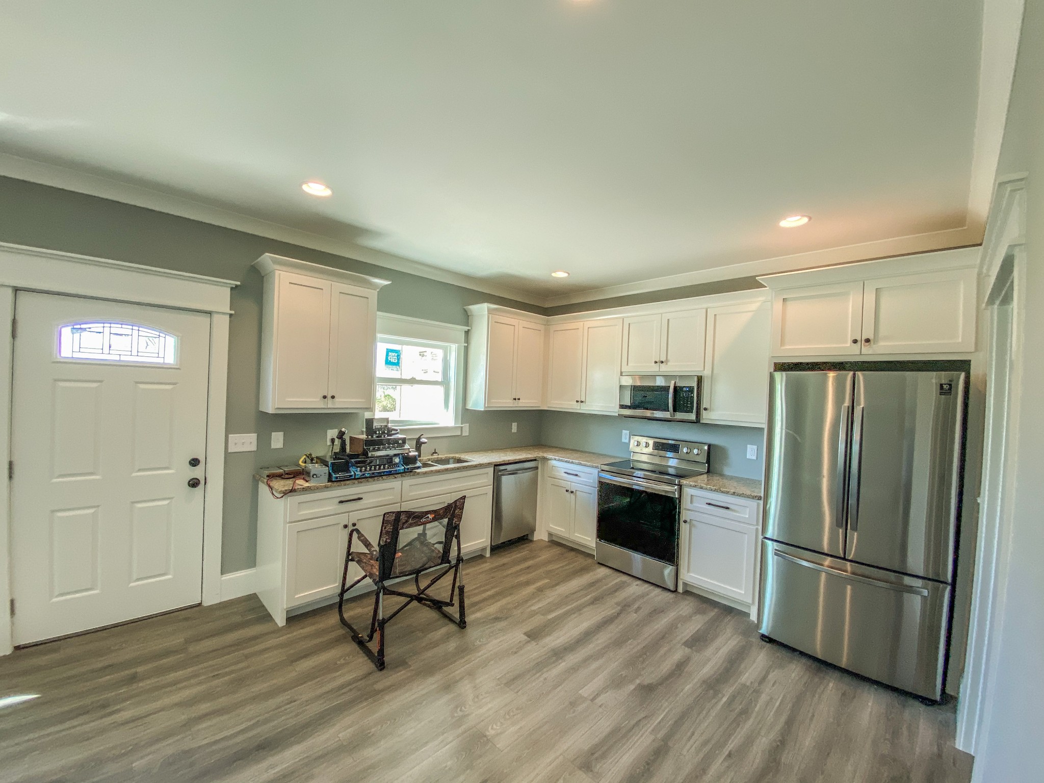 107 Walnut Grove Road Unionville, TN 37180 - Photo 18 of 21 a kitchen with a refrigerator a stove a sink and a dining table with wooden floor