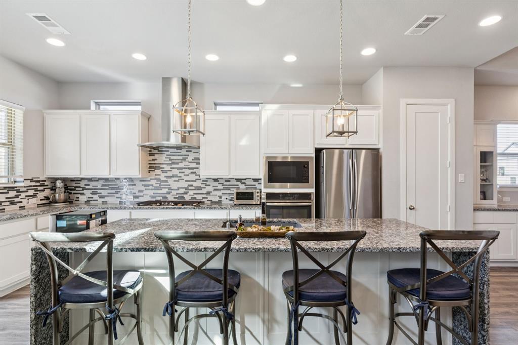 2000 Crescent Street Fort Worth, TX 76008 - Photo 4 of 40 a kitchen with stainless steel appliances a table chairs refrigerator and microwave