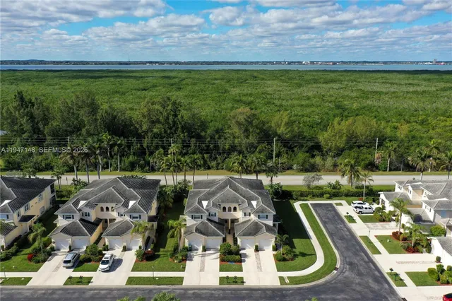a view of swimming pool with lawn chairs and plants