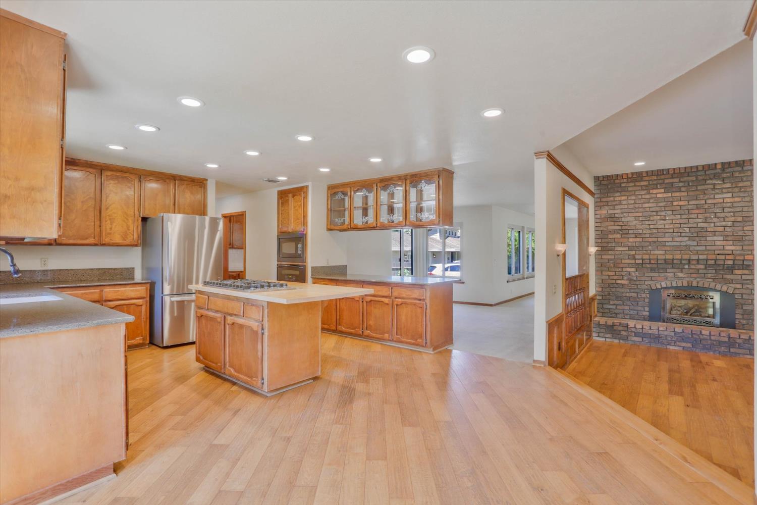 3029 Merrick San Way Carmichael, CA 95608 - Photo 6 of 31 a large kitchen with stainless steel appliances refrigerator a stove top oven with wooden floors