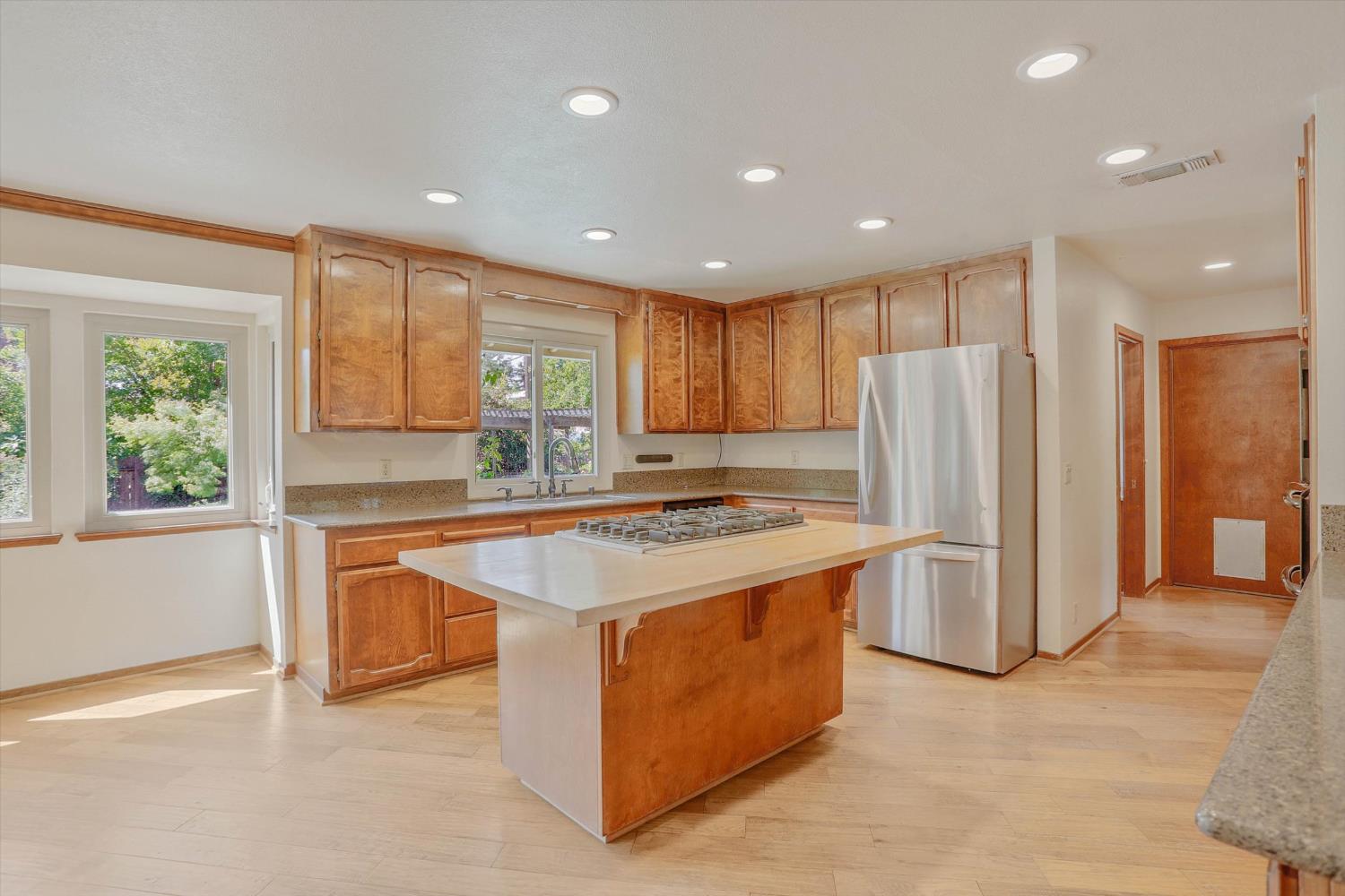 3029 Merrick San Way Carmichael, CA 95608 - Photo 8 of 31 a kitchen with stainless steel appliances granite countertop a refrigerator a sink a stove and a refrigerator with wooden floor
