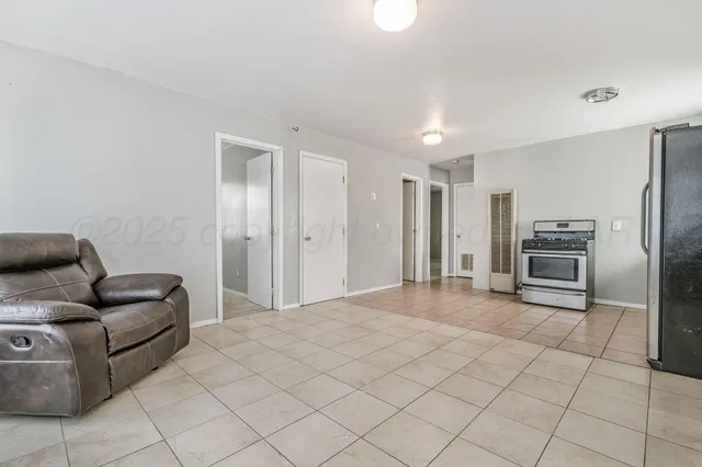 a living room with furniture and a stainless steel appliances
