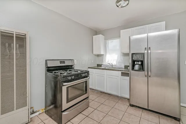 a kitchen with a stove top oven and refrigerator