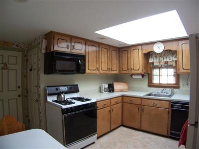 20 Chappaquiddick Road Centerville, MA 02632 - Photo 14 of 22 a kitchen with stainless steel appliances granite countertop a stove a sink dishwasher and a microwave oven with wooden cabinets